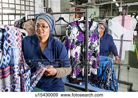 Workers examining dress in garment factory View Large Photo Image Stock Photo - Workers examining dress in garment factory. Fotosearch
