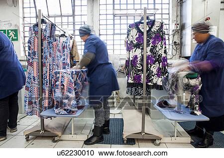 Workers ironing dress in garment factory View Large Photo Image Stock Image - Workers ironing dress in garment factory. Fotosearch