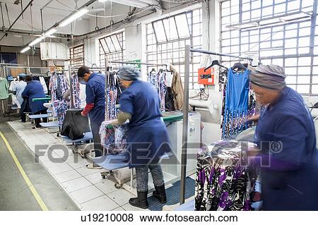 Workers ironing dress in garment factory View Large Photo Image Stock Photo - Workers ironing dress in garment factory. Fotosearch