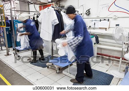 Workers ironing shirt in garment factory View Large Photo Image Stock Image - Workers ironing shirt in garment factory. Fotosearch