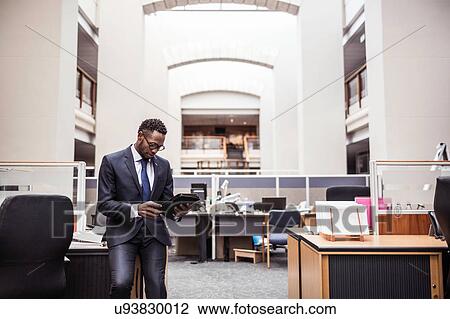 Stock Image - Young businessman using digital tablet in office. Fotosearch