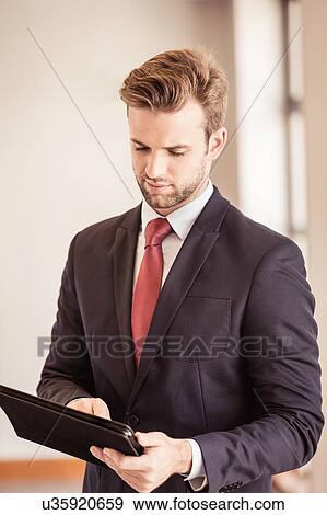 Young businessman using digital tablet touchscreen in office View Large Photo Image Stock Photo - Young businessman using digital tablet touchscreen in office. Fotosearch