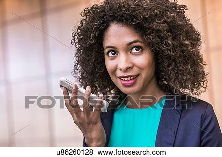 Young businesswoman talking on smartphone in office View Large Photo Image Stock Photo - Young businesswoman talking on smartphone in office. Fotosearch