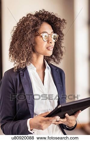 Young businesswoman using digital tablet in office View Large Photo Image Stock Photo - Young businesswoman using digital tablet in office. Fotosearch