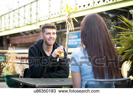 Young couple chatting on terrace View Large Photo Image Stock Image - Young couple chatting on terrace. Fotosearch