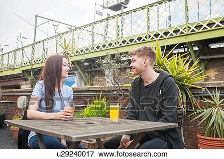 Young couple chatting on terrace View Large Photo Image Stock Photo - Young couple chatting on terrace. Fotosearch
