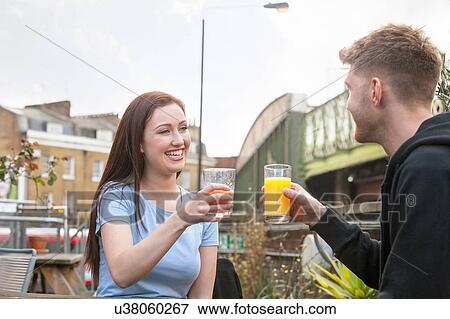 Stock Photo - Young couple chatting on terrace. Fotosearch