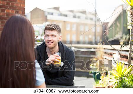 Stock Photo - Young couple chatting on terrace. Fotosearch