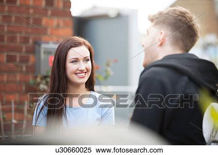 Stock Photography - Young couple chatting on terrace. Fotosearch