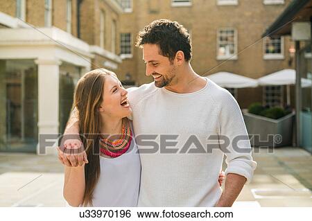 Stock Photograph - Young couple laughing on Kings Road, London, UK. Fotosearch
