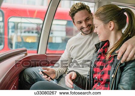 Stock Photo - Young couple on front seat of double-decker, Kings Road, London, UK. Fotosearch