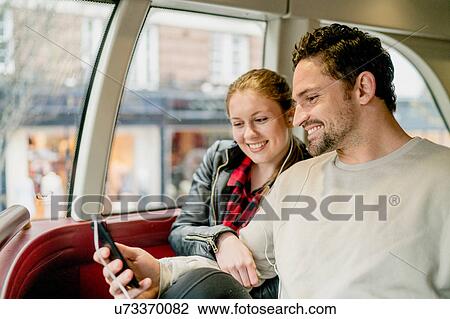 Young couple reading texts on front seat of double-decker, Kings Road, London, UK View Large Photo Image Stock Image - Young couple reading texts on front seat of double-decker, Kings Road, London, UK. Fotosearch