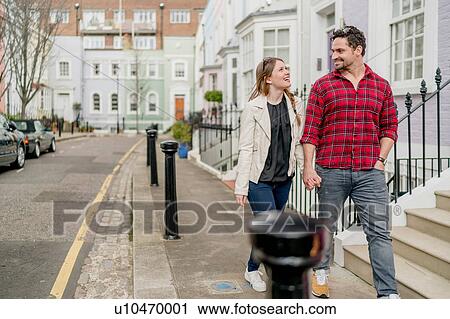 Young couple strolling and holding hands on Kings Road, London, UK View Large Photo Image Stock Image - Young couple strolling and holding hands on Kings Road, London, UK. Fotosearch