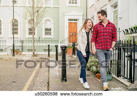 Young couple strolling and holding hands on Kings Road, London, UK View Large Photo Image Stock Photo - Young couple strolling and holding hands on Kings Road, London, UK. Fotosearch