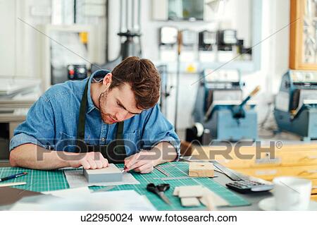 Young craftsman using scalpel and making work in print studio View Large Photo Image Picture - Young craftsman using scalpel and making work in print studio. Fotosearch