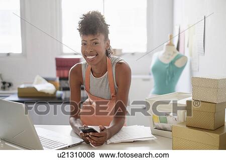 Stock Photo - Young fashion designer in home office. Fotosearch