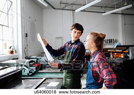 Young male and female craftsperson looking at print in book arts workshop View Large Photo Image Stock Photo - Young male and female craftsperson looking at print in book arts workshop. Fotosearch