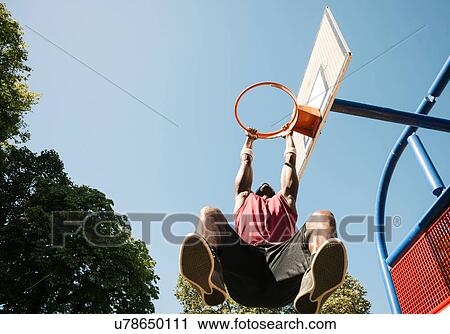 Young male basketball player hanging from basketball hoop View Large Photo Image Stock Image - Young male basketball player hanging from basketball hoop. Fotosearch