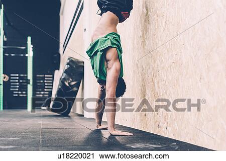 Young male cross trainer doing handstand in gym View Large Photo Image Stock Image - Young male cross trainer doing handstand in gym. Fotosearch