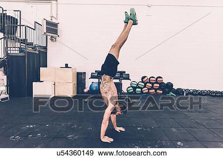 Young male cross trainer doing handstand in gym View Large Photo Image Stock Photo - Young male cross trainer doing handstand in gym. Fotosearch