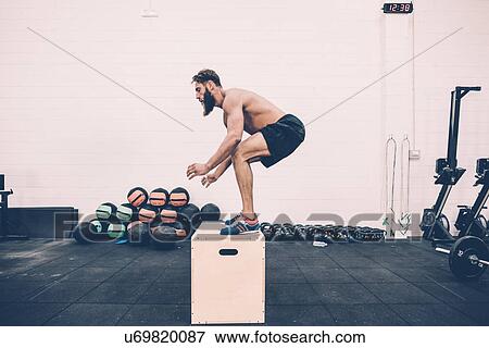 Young male cross trainer jumping on box in gym View Large Photo Image Stock Photo - Young male cross trainer jumping on box in gym. Fotosearch