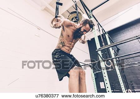 Young male cross trainer training on gymnastic rings View Large Photo Image Stock Photo - Young male cross trainer training on gymnastic rings. Fotosearch