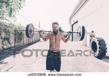 Young male cross trainer weightlifting barbell outside gym View Large Photo Image Stock Photo - Young male cross trainer weightlifting barbell outside gym. Fotosearch