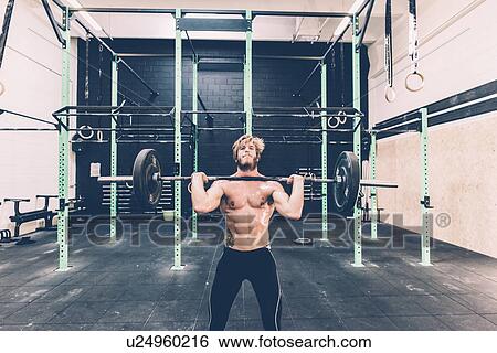 Young male cross trainer weightlifting barbell in gym View Large Photo Image Stock Photograph - Young male cross trainer weightlifting barbell in gym. Fotosearch