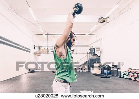 Young male cross trainer weightlifting kettlebell in gym View Large Photo Image Stock Photography - Young male cross trainer weightlifting kettlebell in gym. Fotosearch