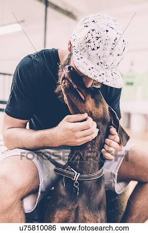 Young male hipster petting dog View Large Photo Image Stock Photograph - Young male hipster petting dog. Fotosearch