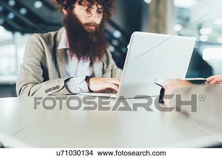 Young male hipster using laptop at desk View Large Photo Image Picture - Young male hipster using laptop at desk. Fotosearch