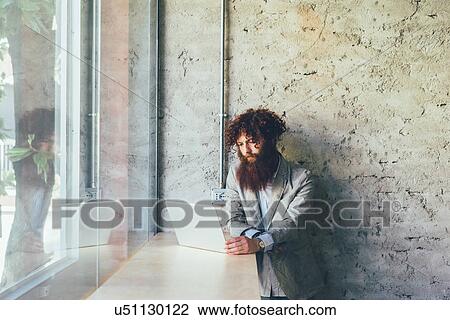Young male hipster with curly red hair and beard using laptop in office View Large Photo Image Stock Image - Young male hipster with curly red hair and beard using laptop in office. Fotosearch