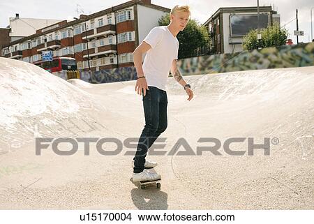 Young male skateboarder skateboarding in skatepark View Large Photo Image Picture - Young male skateboarder skateboarding in skatepark. Fotosearch