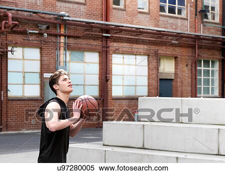 Young man playing basketball in outdoor court View Large Photo Image Stock Photography - Young man playing basketball in outdoor court. Fotosearch