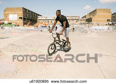 Young man riding BMX bicycle in skatepark View Large Photo Image Stock Photography - Young man riding BMX bicycle in skatepark. Fotosearch