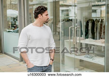 Stock Image - Young man window shopping on Kings Road, London, UK. Fotosearch