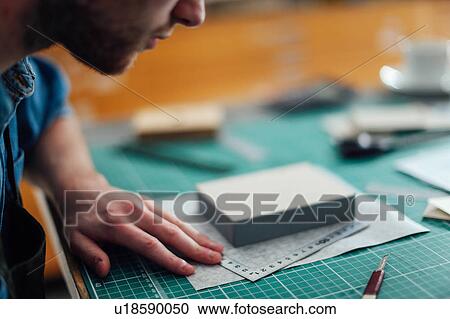 Stock Image - Young man working in print studio, close-up. Fotosearch