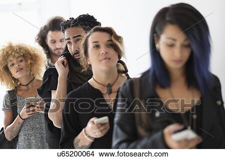 Young people standing in line using smartphones View Large Photo Image Picture - Young people standing in line using smartphones. Fotosearch