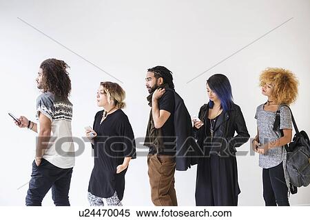 Young people standing in line using smartphones View Large Photo Image Stock Photography - Young people standing in line using smartphones. Fotosearch