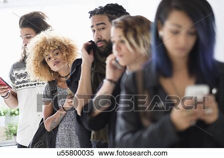 Young people standing in line using smartphones View Large Photo Image Stock Photography - Young people standing in line using smartphones. Fotosearch