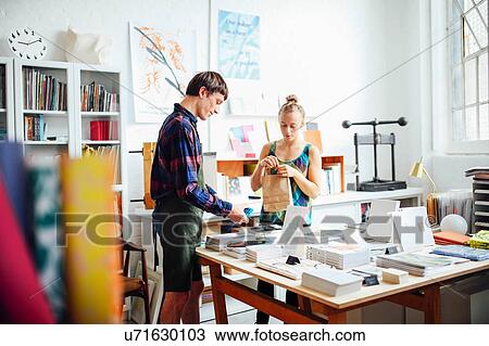 Young woman buying book from young craftsman in art bookshop View Large Photo Image Stock Image - Young woman buying book from young craftsman in art bookshop. Fotosearch
