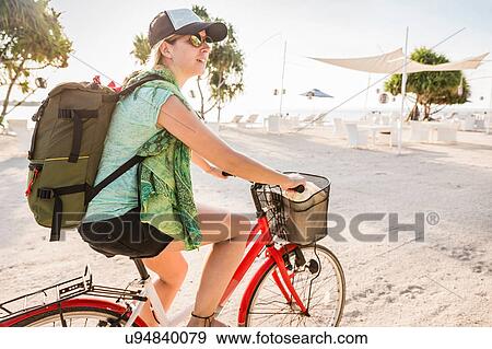 Young woman cycling on beach, Gili Meno, Lombok, Indonesia View Large Photo Image Stock Photo - Young woman cycling on beach, Gili Meno, Lombok, Indonesia. Fotosearch