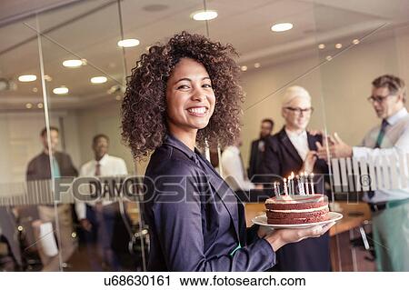 Young woman presenting cake with candles to business team in boardroom View Large Photo Image Stock Image - Young woman presenting cake with candles to business team in boardroom. Fotosearch