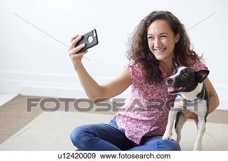 Young woman taking selfie with her dog View Large Photo Image Stock Photo - Young woman taking selfie with her dog. Fotosearch