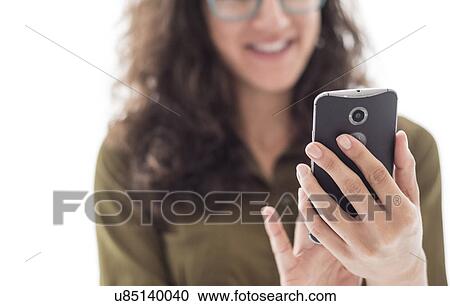 Stock Image - Young woman using smart phone. Fotosearch