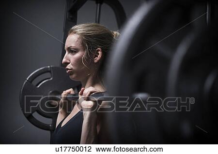 Young woman weightlifting in gym View Large Photo Image Stock Image - Young woman weightlifting in gym. Fotosearch
