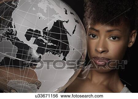 Stock Photograph - Young woman with transparent globe. Fotosearch
