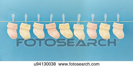 Stock Photo - Baby socks hanging on washing line. Fotosearch