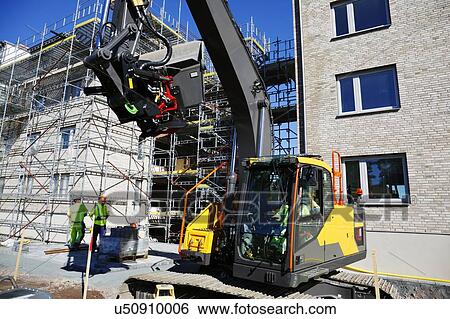 Construction workers on site with digger View Large Photo Image Stock Photograph - Construction workers on site with digger. Fotosearch