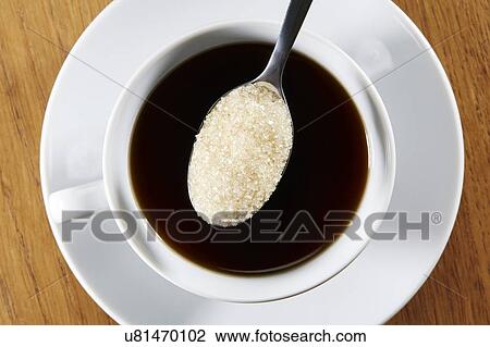 Stock Image - Cup of black coffee with spoonful of sugar. Fotosearch